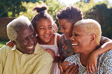 Older couple with grandchildren smiling looking at each other